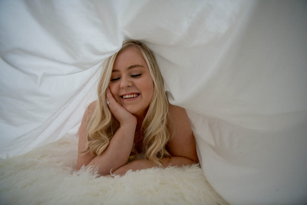 Don't stress about what to wear for your boudoir photos. Some outfits can be as simple as a smile and a bed sheet!